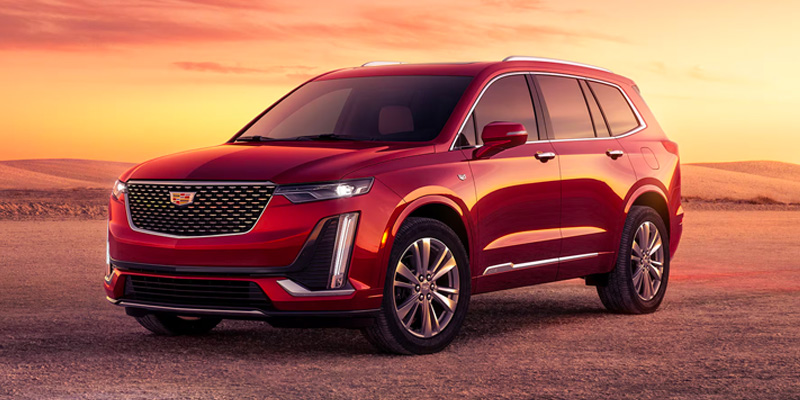 A red 2025 Cadillac XT6 parked in a dirt patch