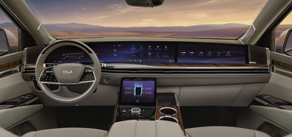 Interior view of a Cadillac Escalade, showcasing a sleek dashboard with digital displays and high-end finishes.
