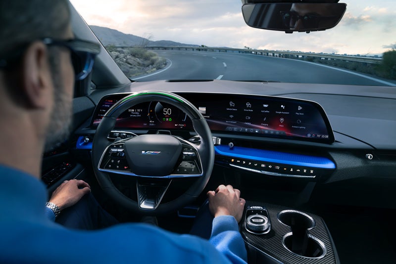 Front View of the 2026 OPTIQ-V Driving Through the Dusk Utilizing its Headlights | Schwan Cadillac in Mandan ND